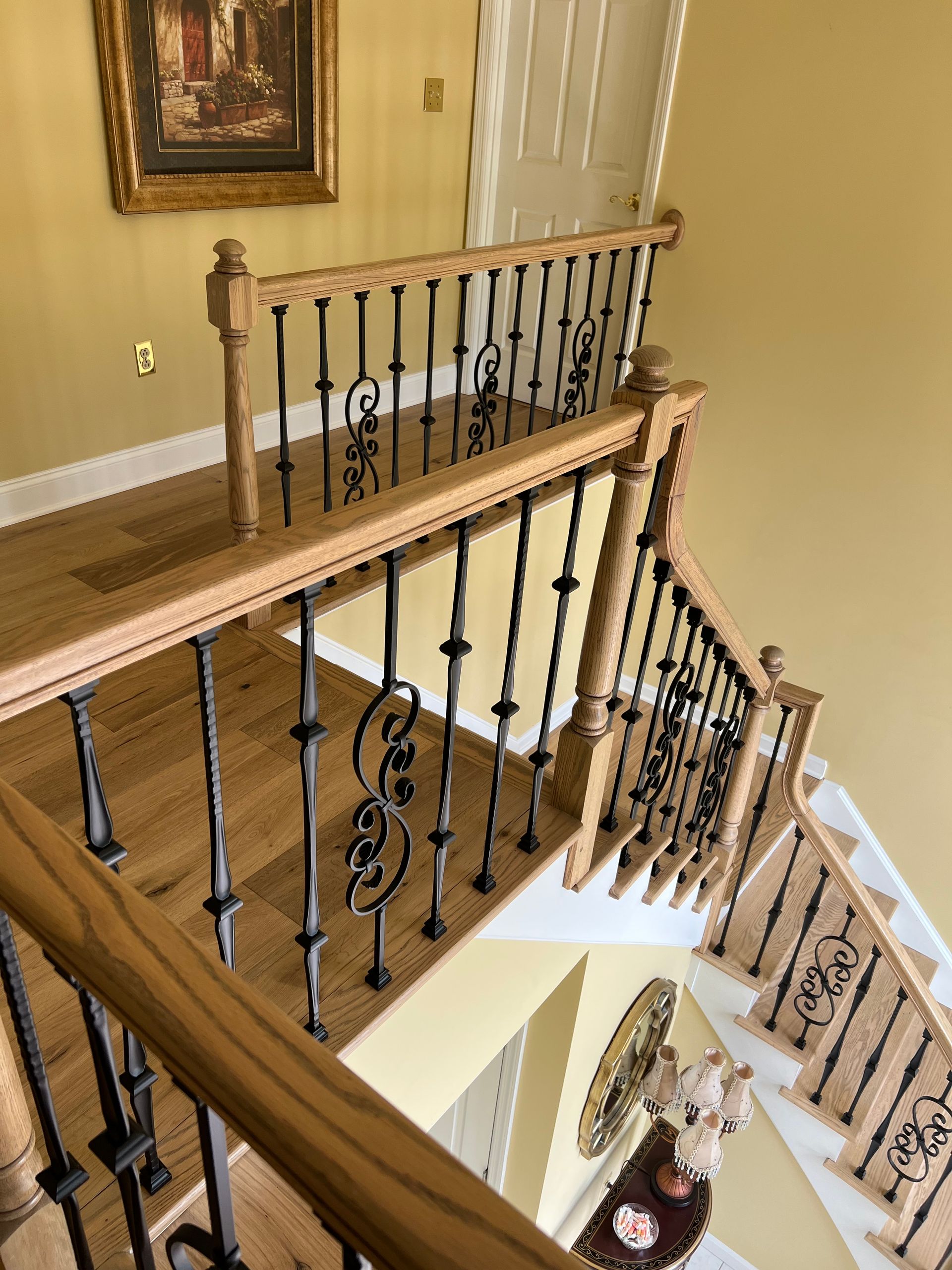 A wooden staircase with a wrought iron railing in a house.