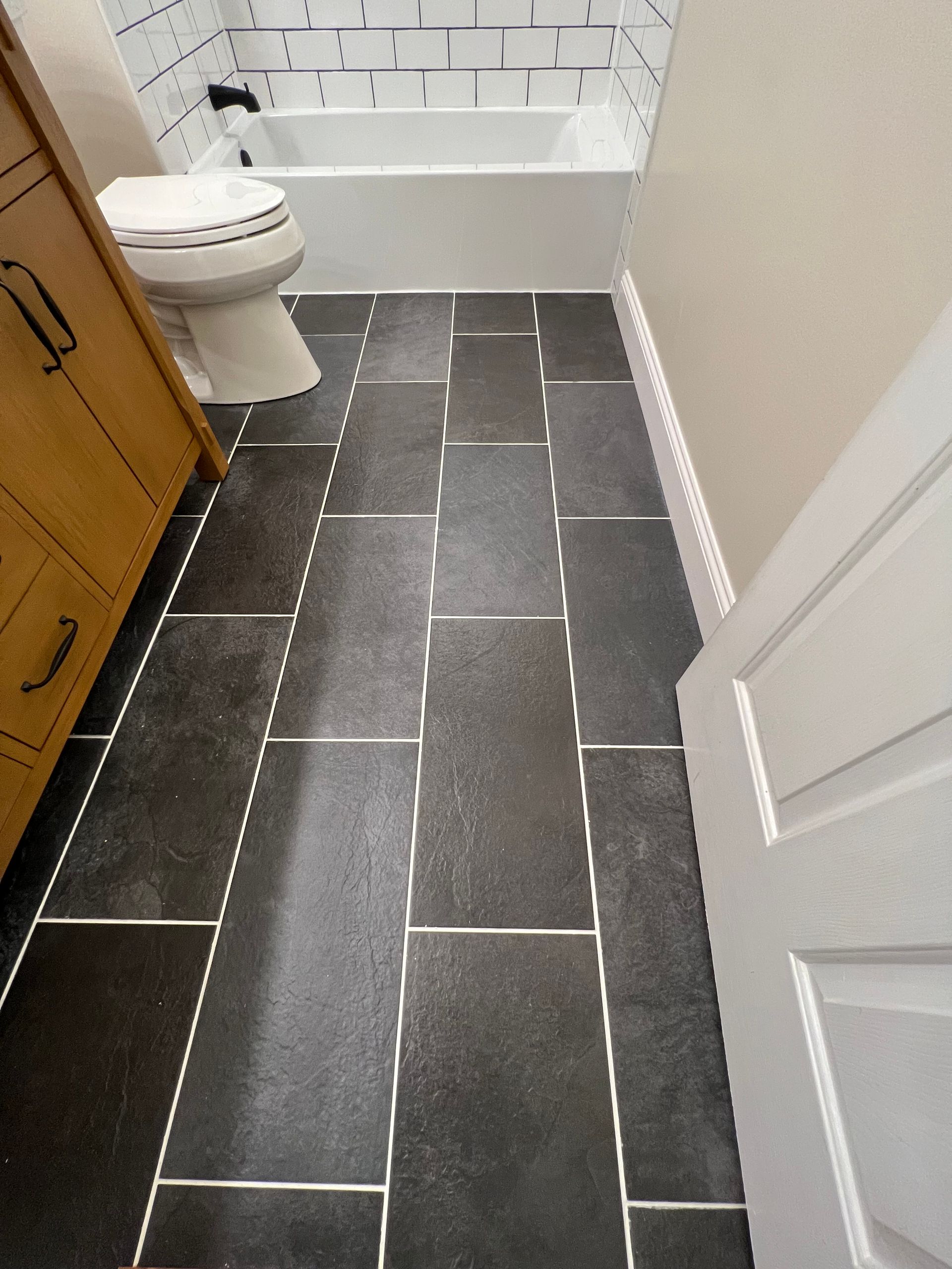 A bathroom with a toilet , sink and bathtub.