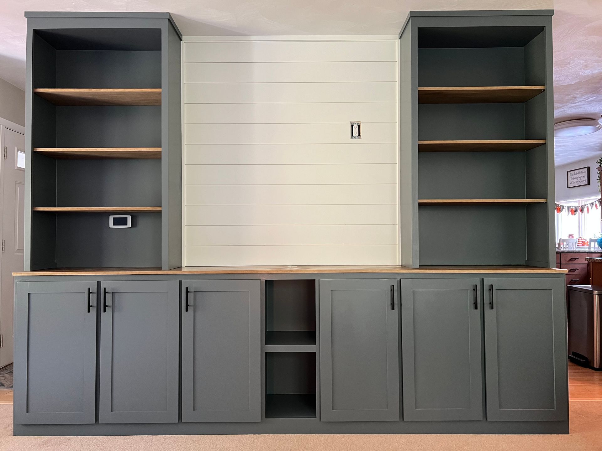 A living room with a lot of cabinets and shelves.