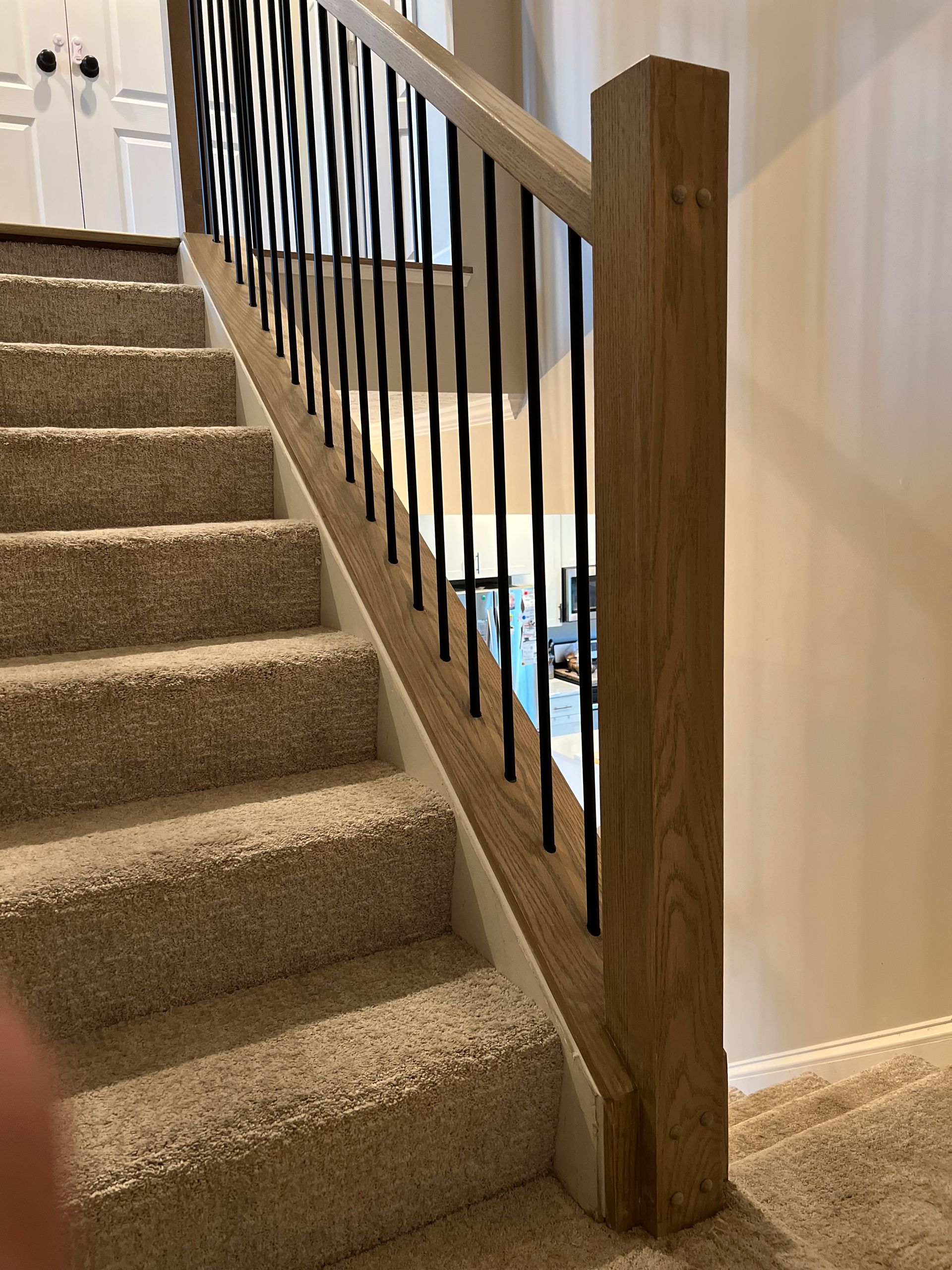 A staircase with a wooden railing and carpeted steps in a house.