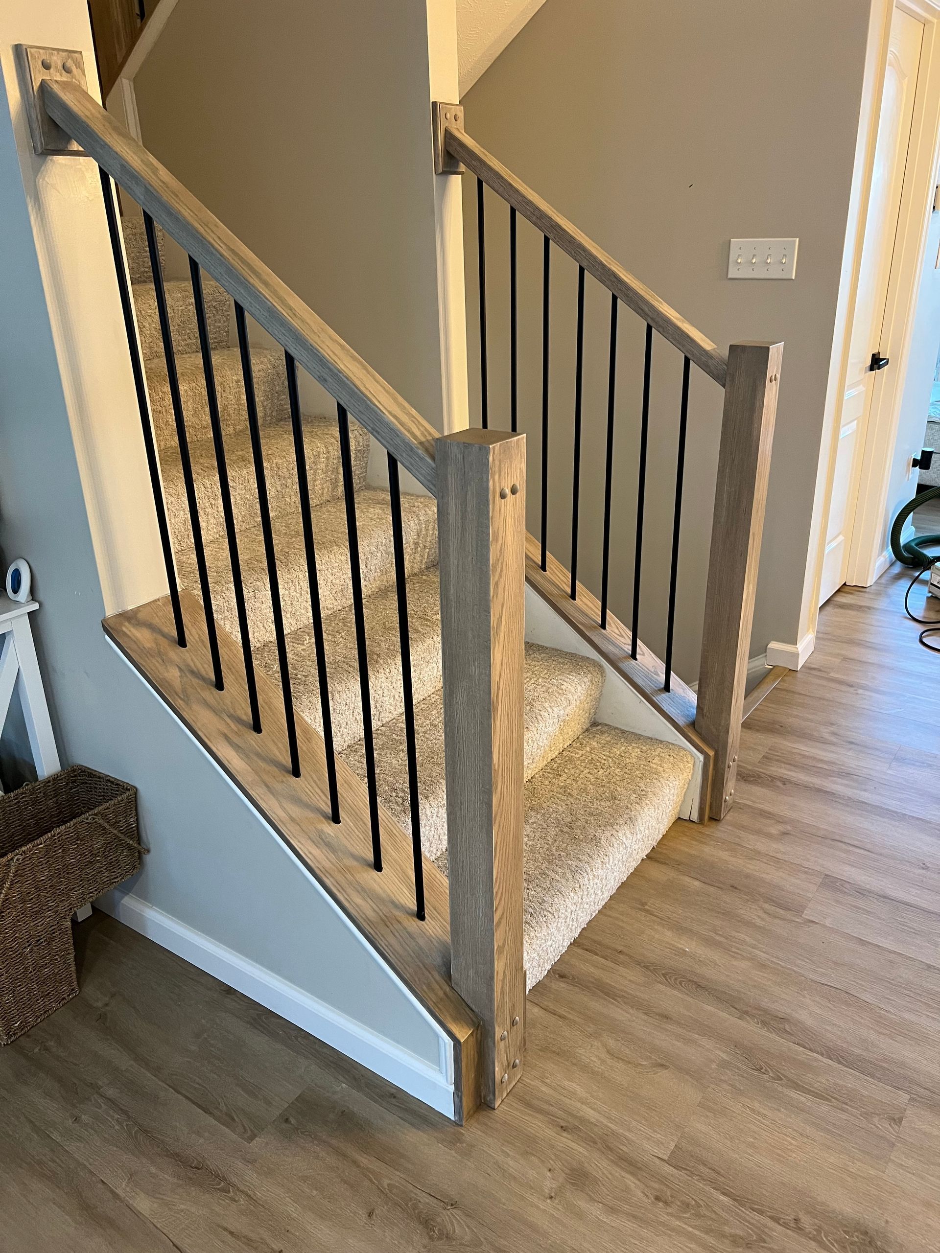 A wooden staircase with a metal railing in a house.