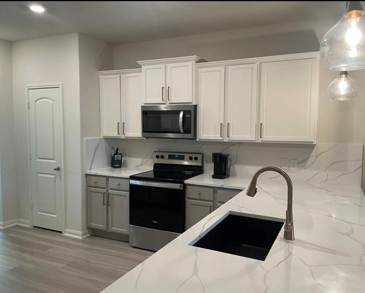 A large outdoor kitchen with a grill and a sink.