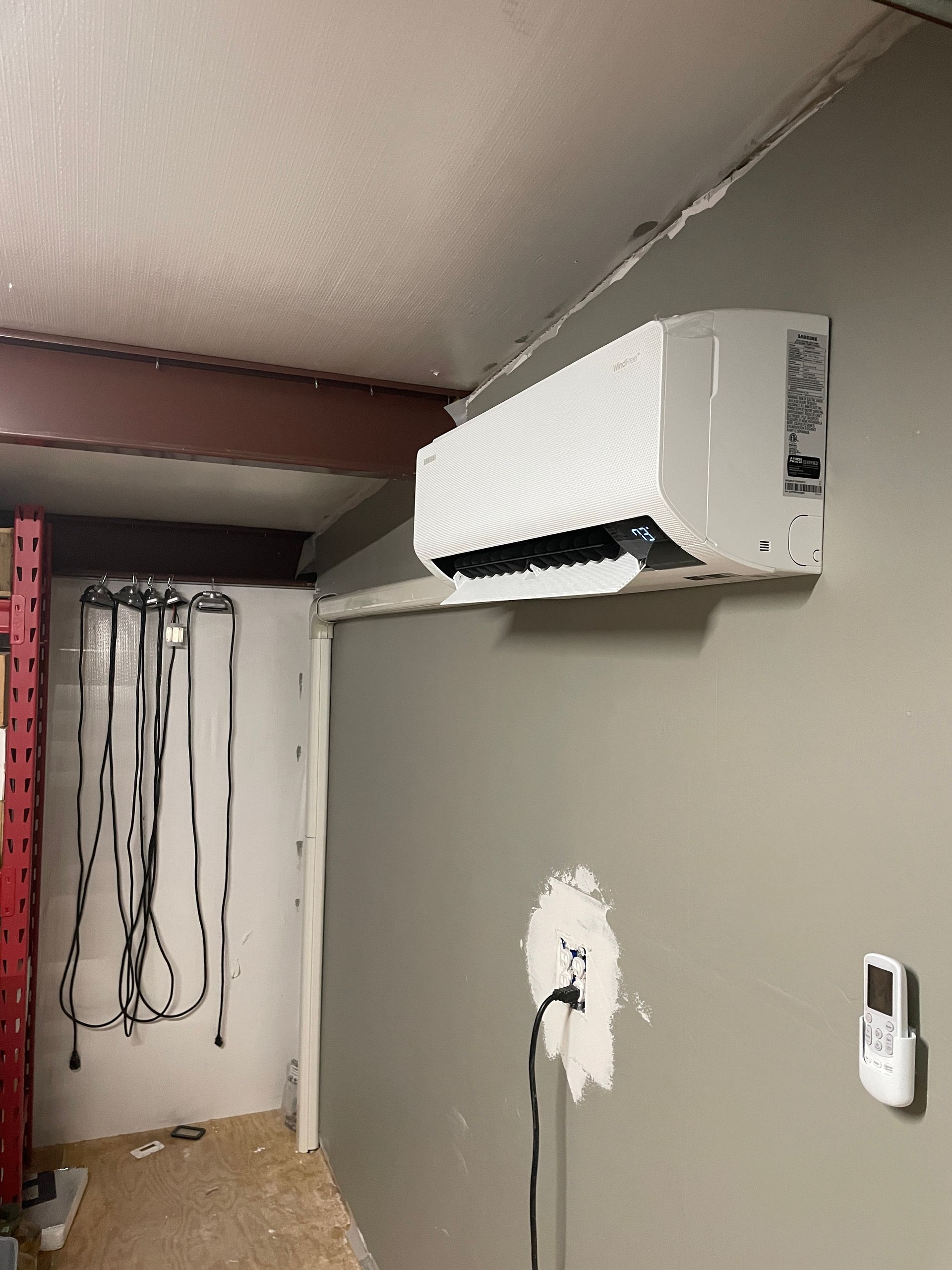 A room with a radiator and potted plants in front of a window.