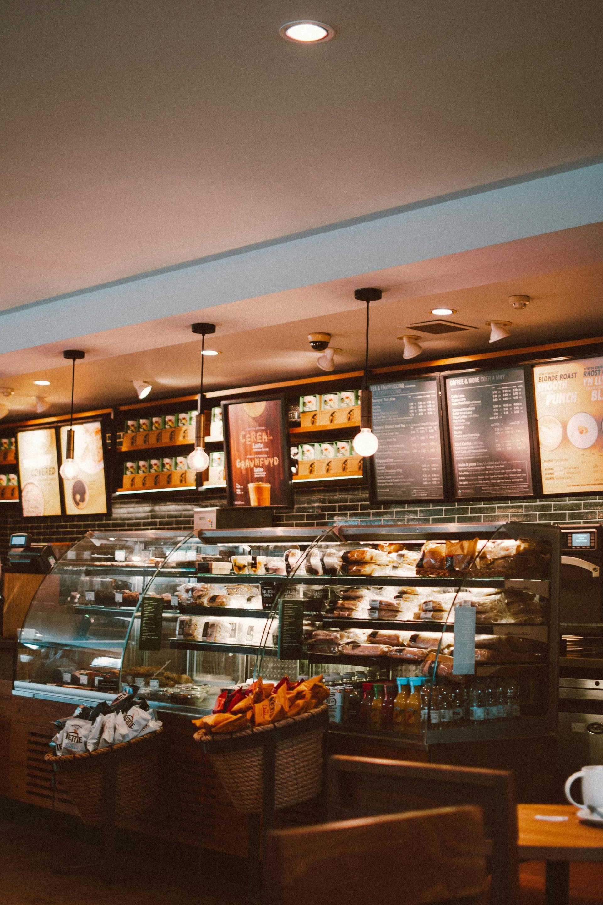 A coffee shop with a display case full of food