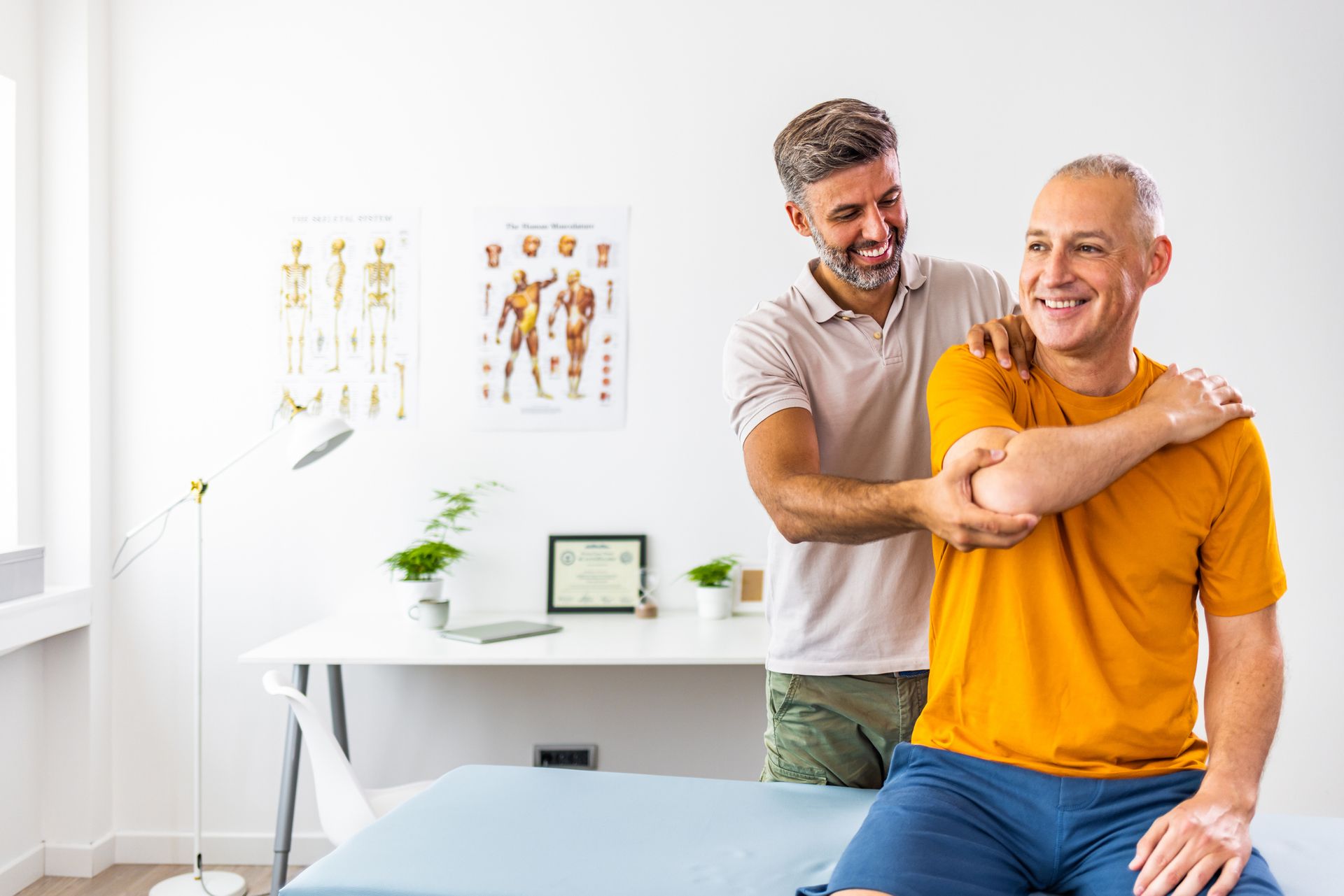 A man is sitting on a bed getting a massage from a doctor.