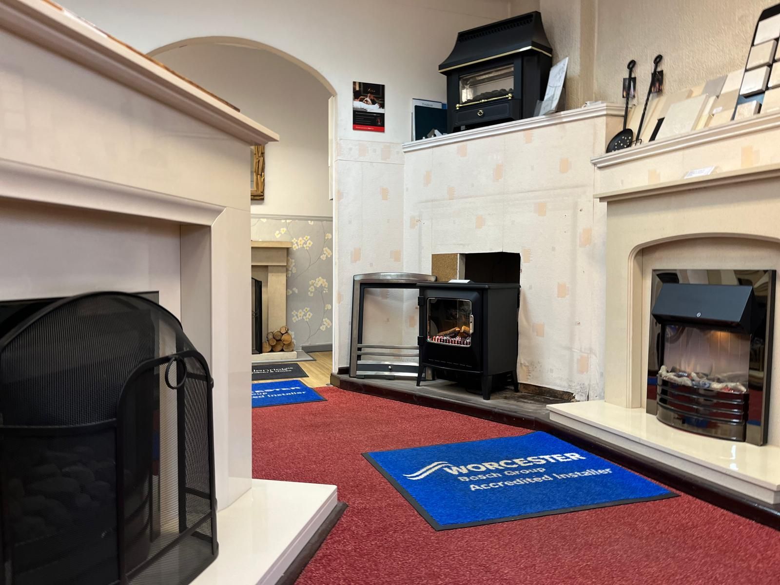 A room with a lot of fireplaces and a blue rug that says ' showroom ' on it.