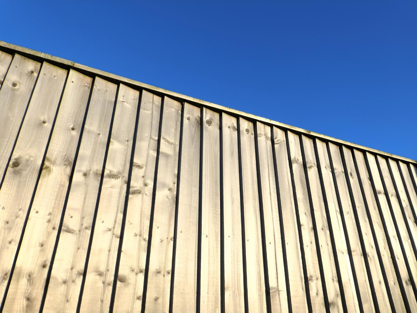 Wooden Fence Against a Bright Blue Sky — LD Carpentry in Bowral, NSW