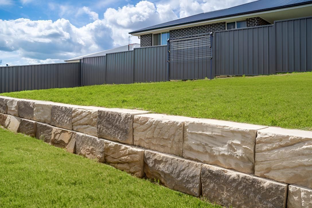 Stone Retaining Wall Separating Green Lawn — LD Carpentry in Goulburn, NSW
