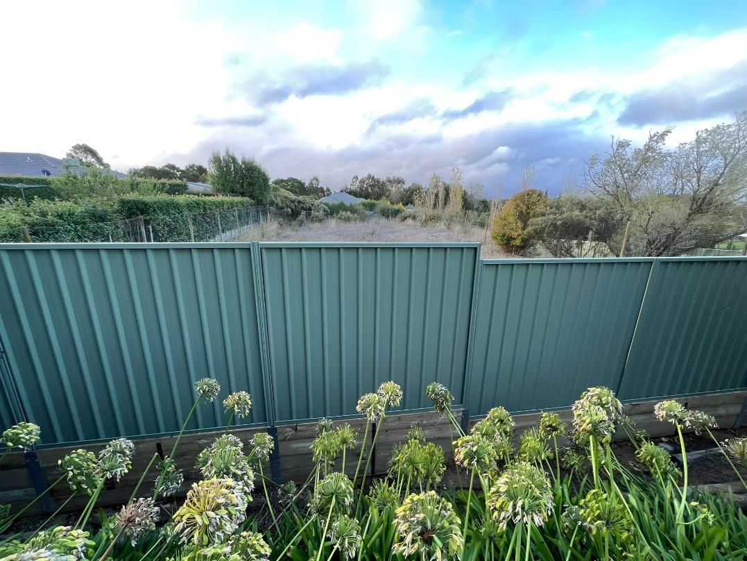 Green Fence in Front of a Garden — LD Carpentry in Canberra, ACT