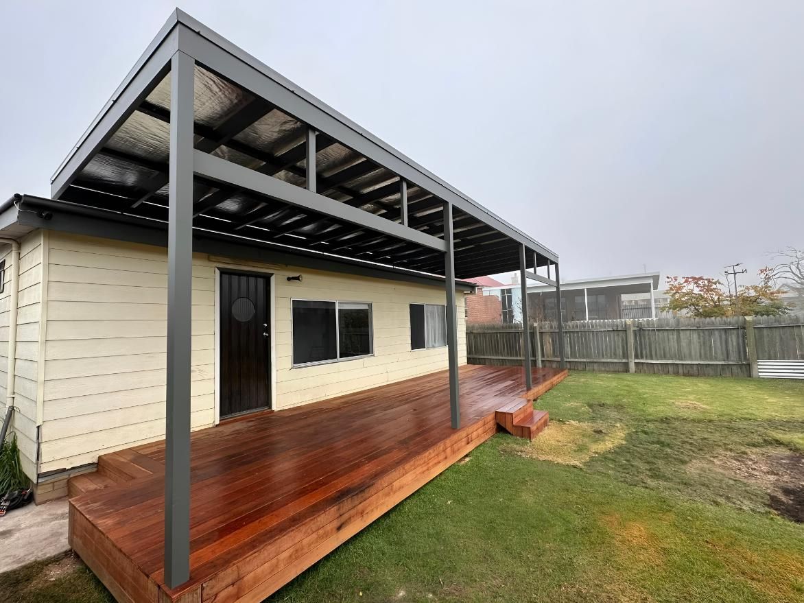 Gray Pergola Covers a Wooden Deck — LD Carpentry in Moss Vale, NSW