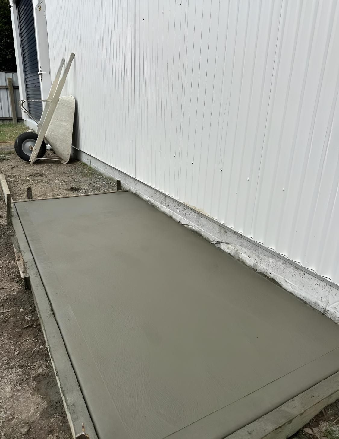 Freshly Poured Concrete Slab Next to a White Building — LD Carpentry in Bowral, NSW