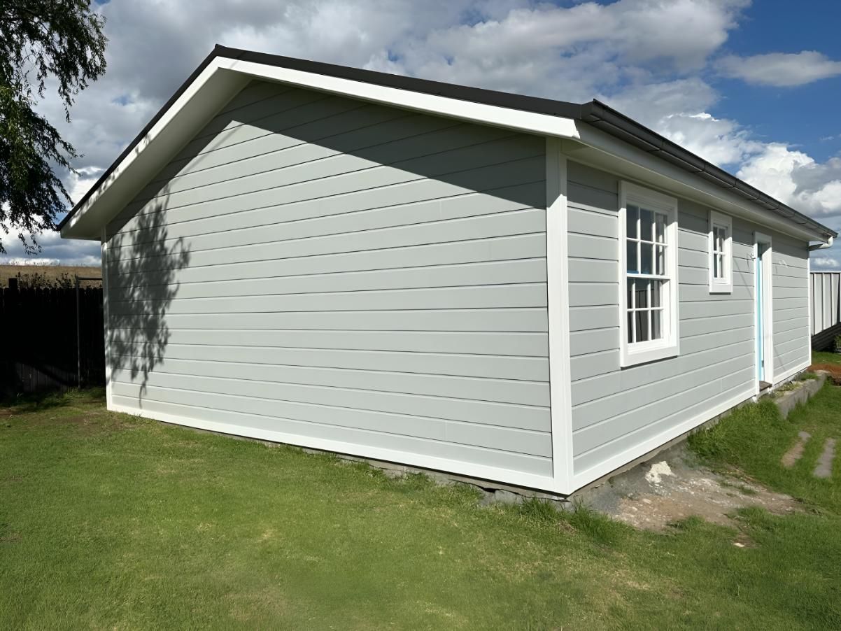 Shed With White Trim and Two Windows on Green Lawn — LD Carpentry in Bowral, NSW