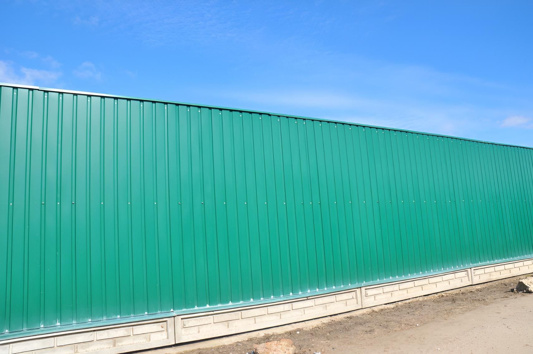 Green Metal Fence Against a Blue Sky — LD Carpentry in Queanbeyan, NSW