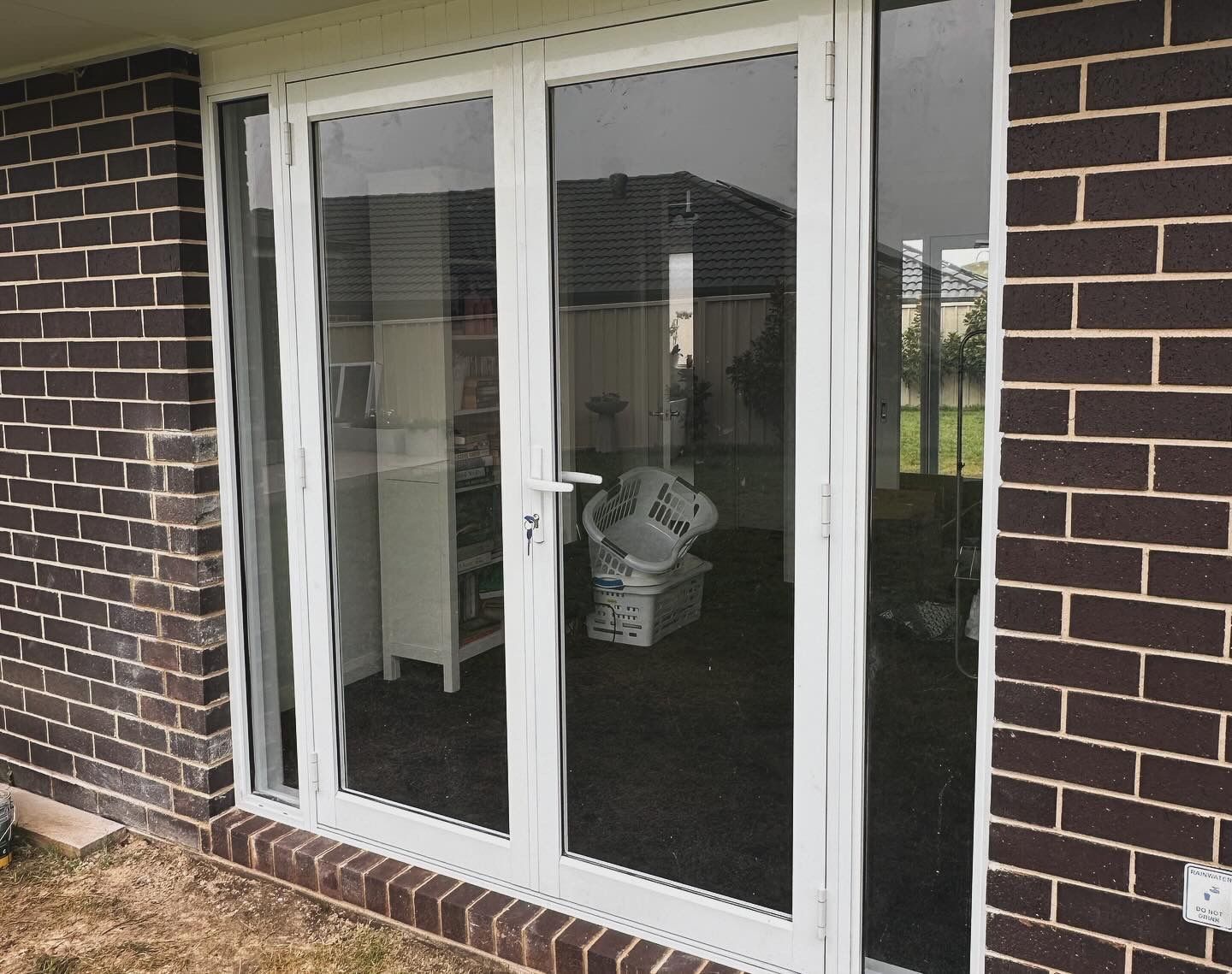 White-framed glass double doors set in a brick wall — LD Carpentry in Goulburn, NSW