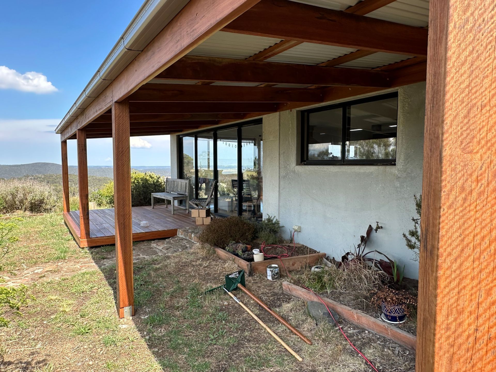 Covered wooden deck and house exterior with a garden bed — LD Carpentry in Goulburn, NSW