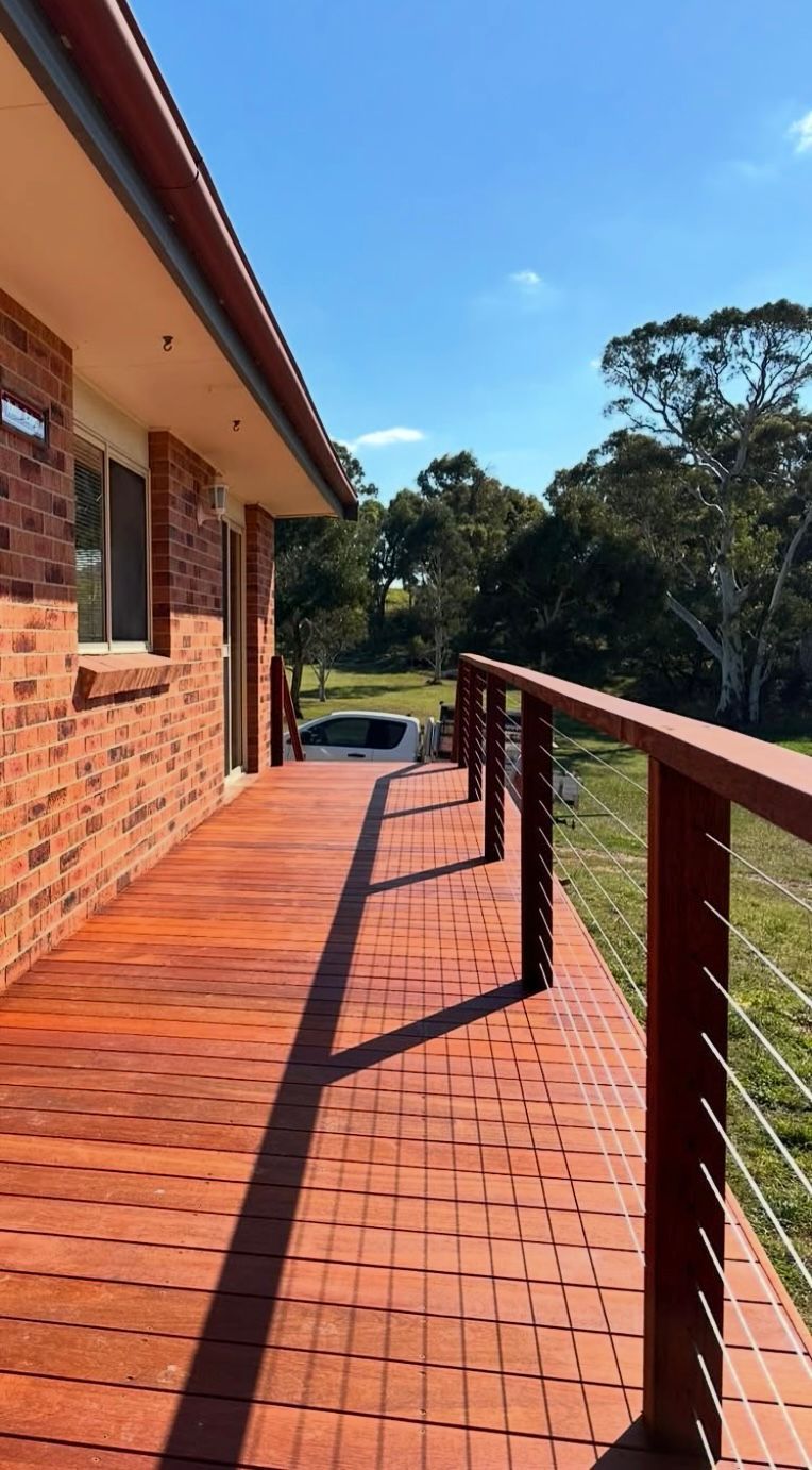 Red brick house with wooden deck and railing — LD Carpentry in Goulburn, NSW
