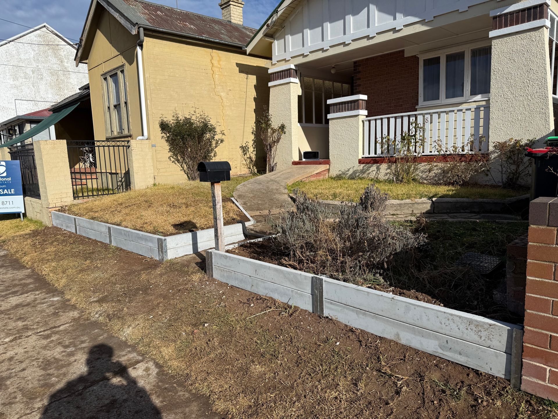 Front yards with concrete borders, mailbox, two houses, one yellow, one beige — LD Carpentry in Goulburn, NSW