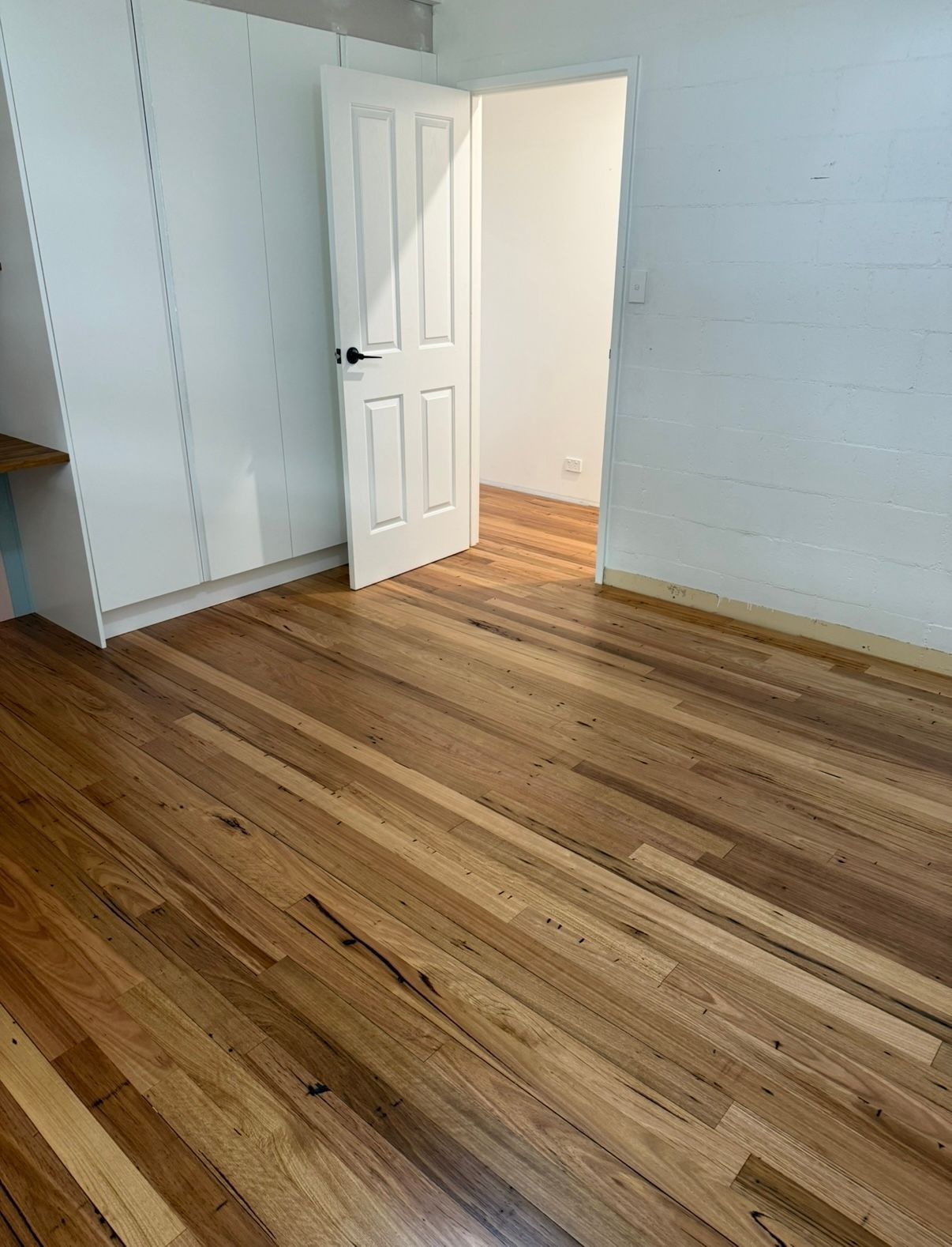 Wooden-floored room with white built-in storage and an open door — LD Carpentry in Goulburn, NSW