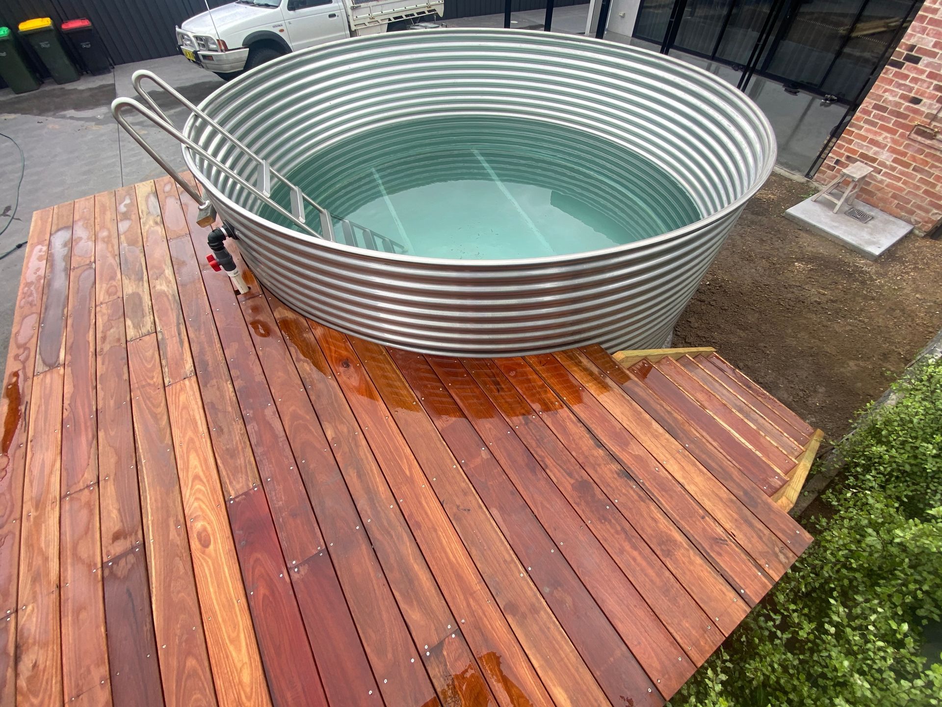 Stock tank pool surrounded by a wooden deck with stairs — LD Carpentry in Goulburn, NSW