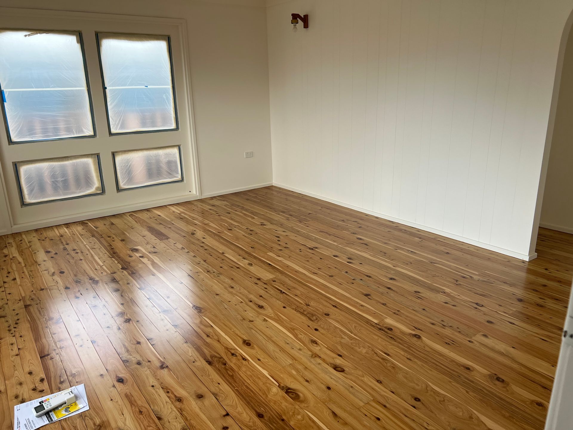Empty room with polished wooden floor and windows — LD Carpentry in Goulburn, NSW