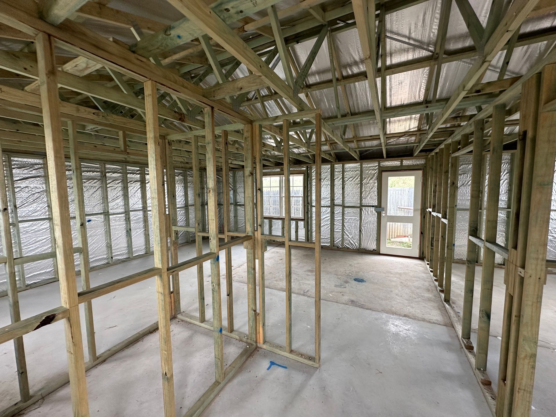 Interior of a building under construction with wooden framing and insulation — LD Carpentry in Goulburn, NSW