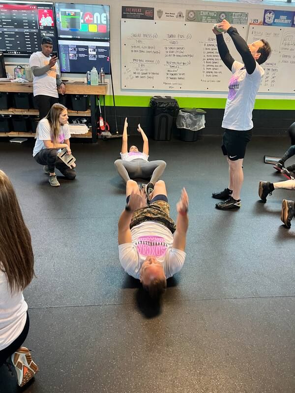 A group of people are doing exercises in a gym.