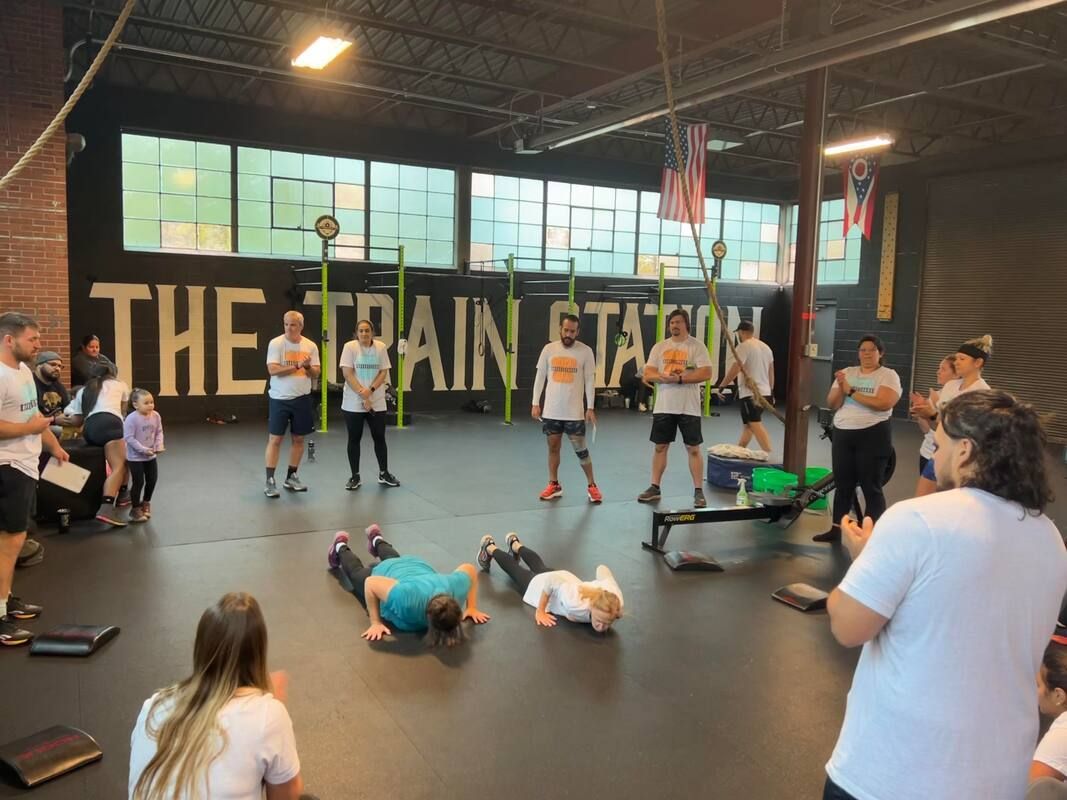 A group of people are doing push ups in a gym.