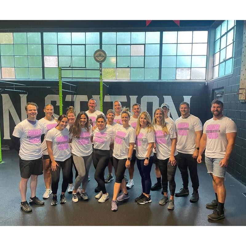 A group of people are posing for a picture in a gym.
