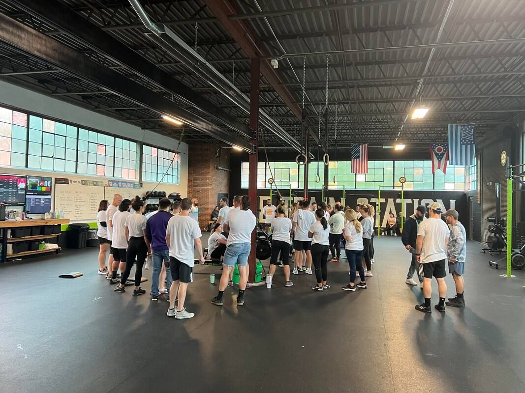A group of people are standing in a gym.