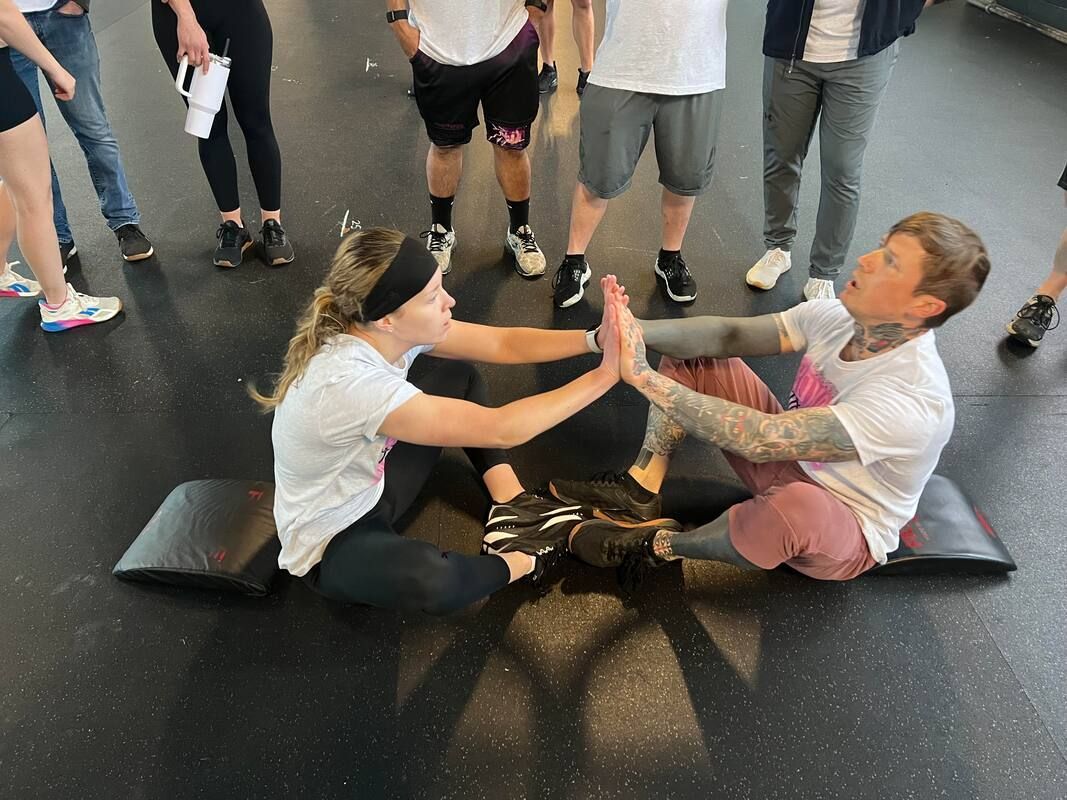 A group of people are sitting on the floor giving each other a high five.
