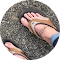 A close up of a person 's foot wearing a pair of flip flops.