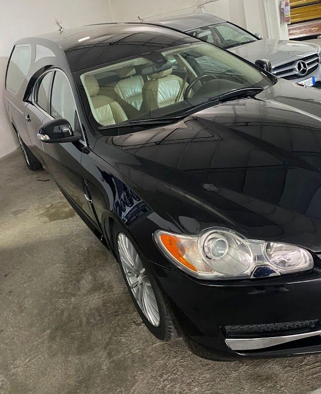 una jaguar nera è parcheggiata in un garage accanto a una mercedes