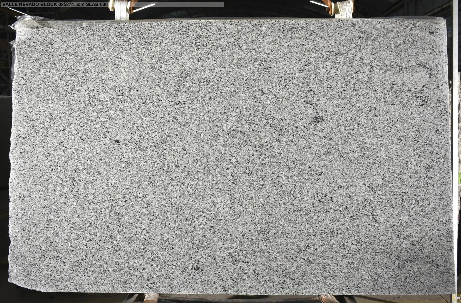 Gray speckled foam board clipped at the top and resting on a dark surface