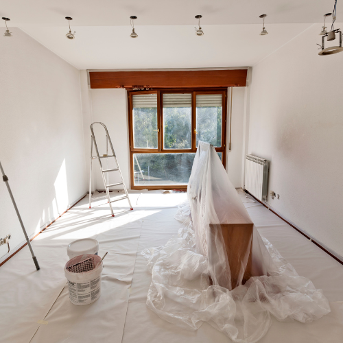 A prepped room with drop sheets and plastic covers ready for painting