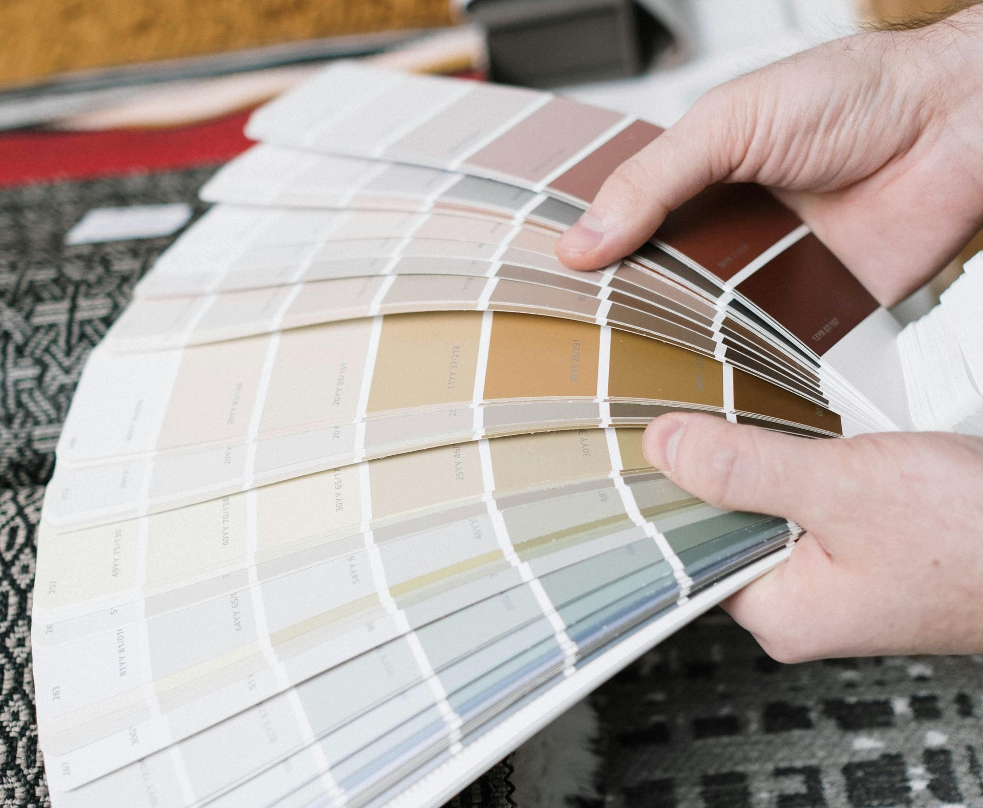 Modern buildings with colourful and glass facades, with green trees in the foreground.