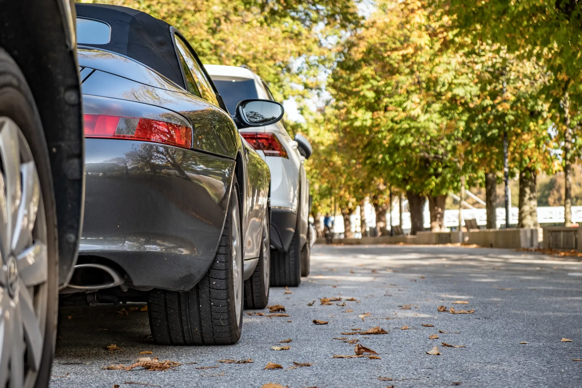 A row of cars are parked on the side of a road.