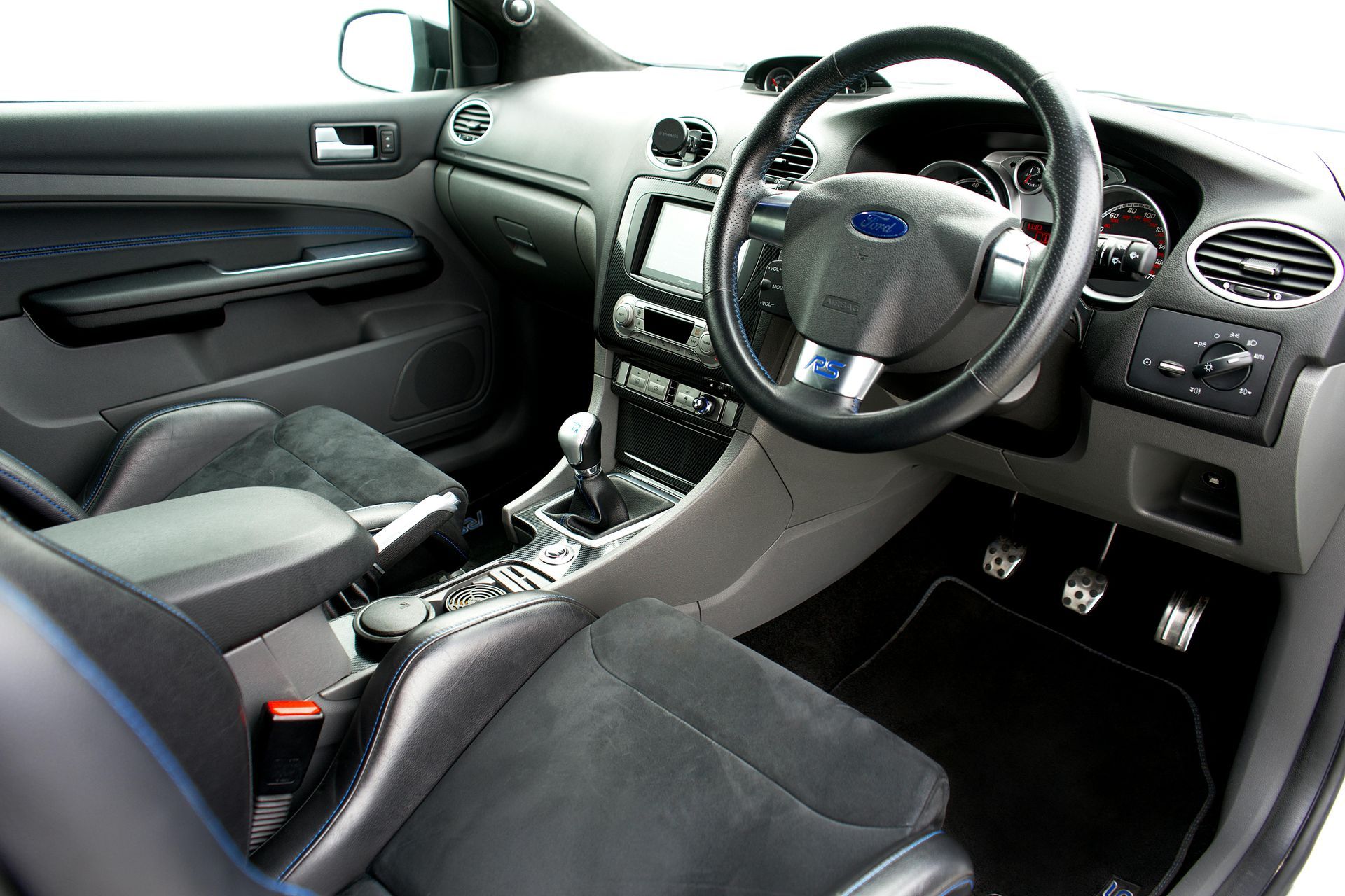 The interior of a car with a steering wheel and dashboard