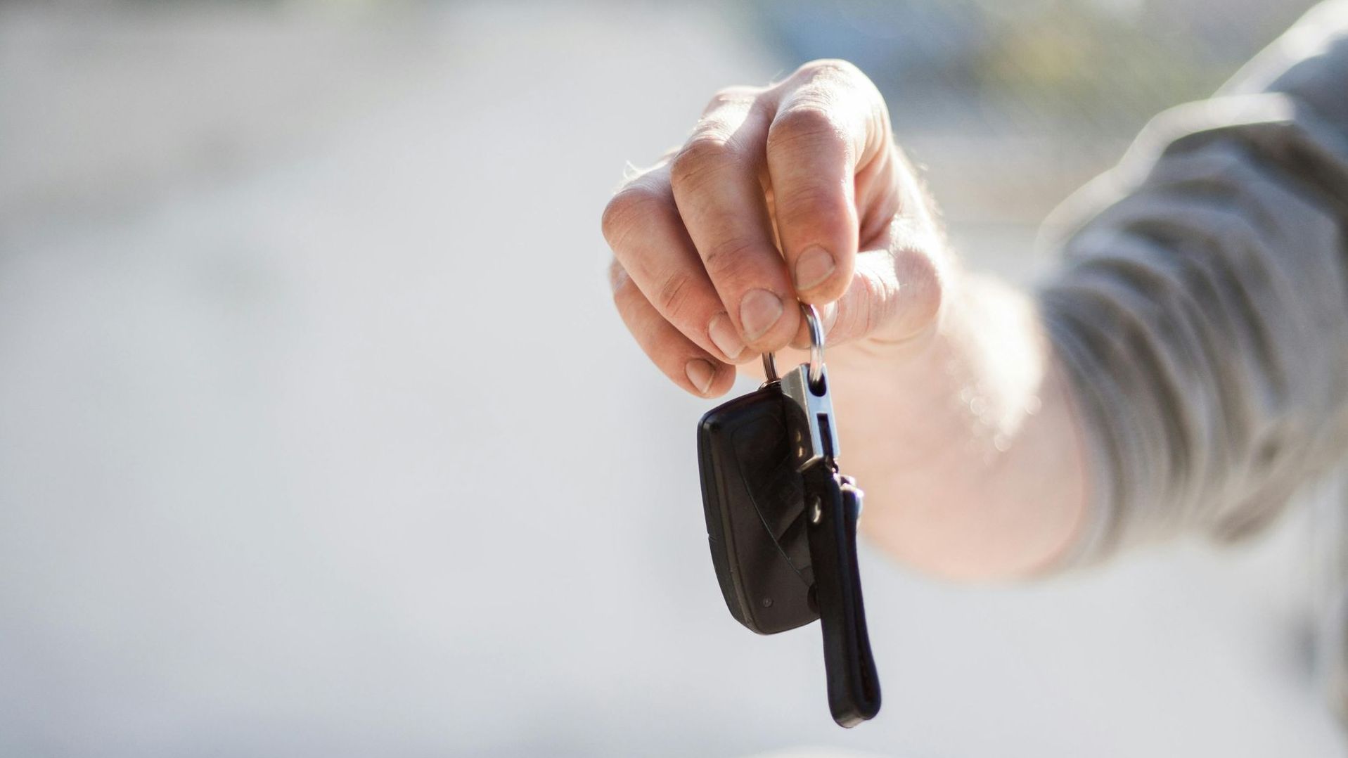 A person is holding a car key in their hand.