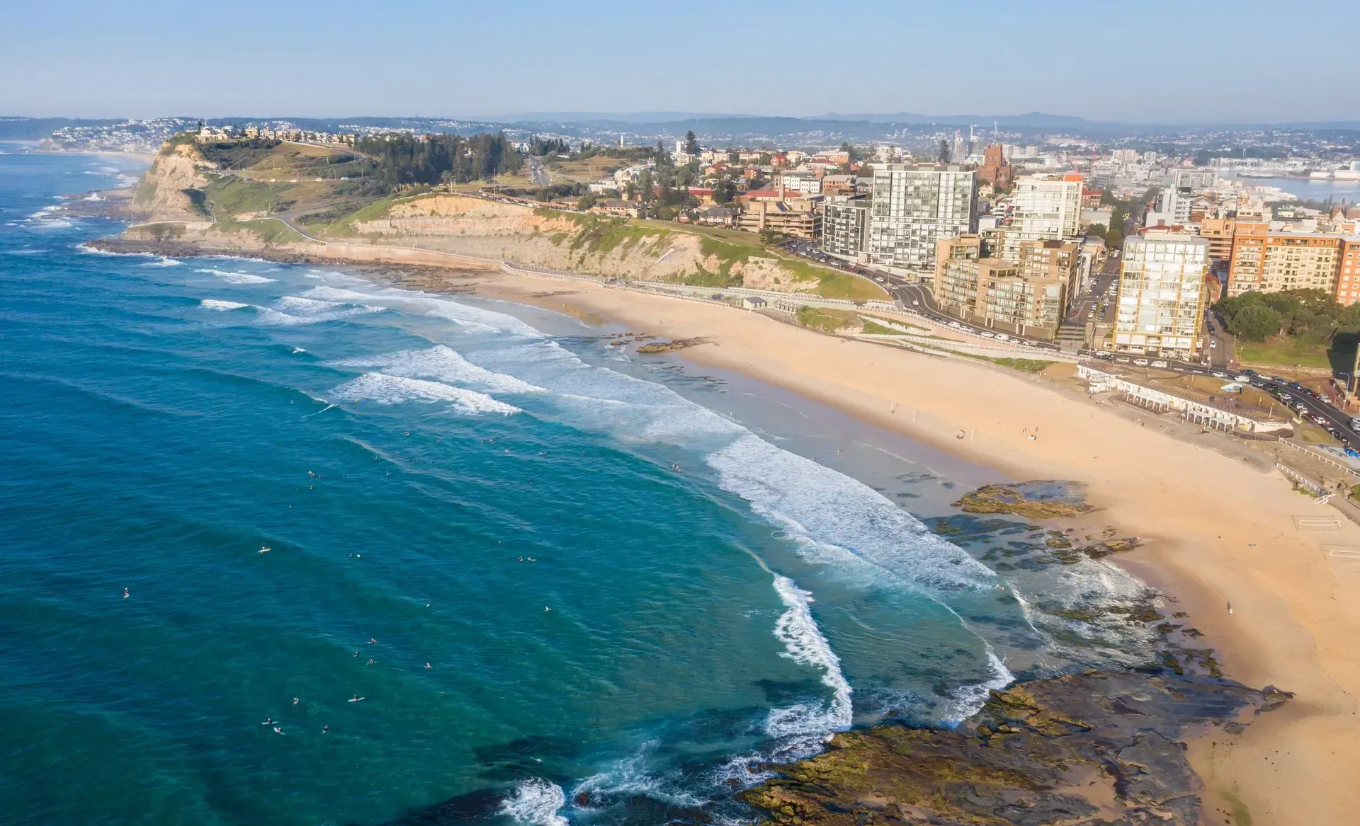 An aerial view of a beach with a city in the background.