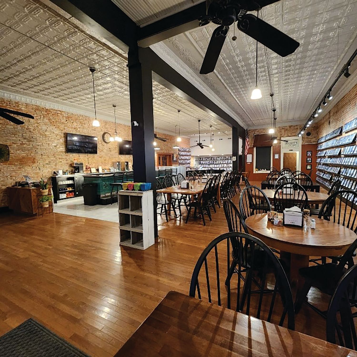 A restaurant with tables and chairs and a ceiling fan