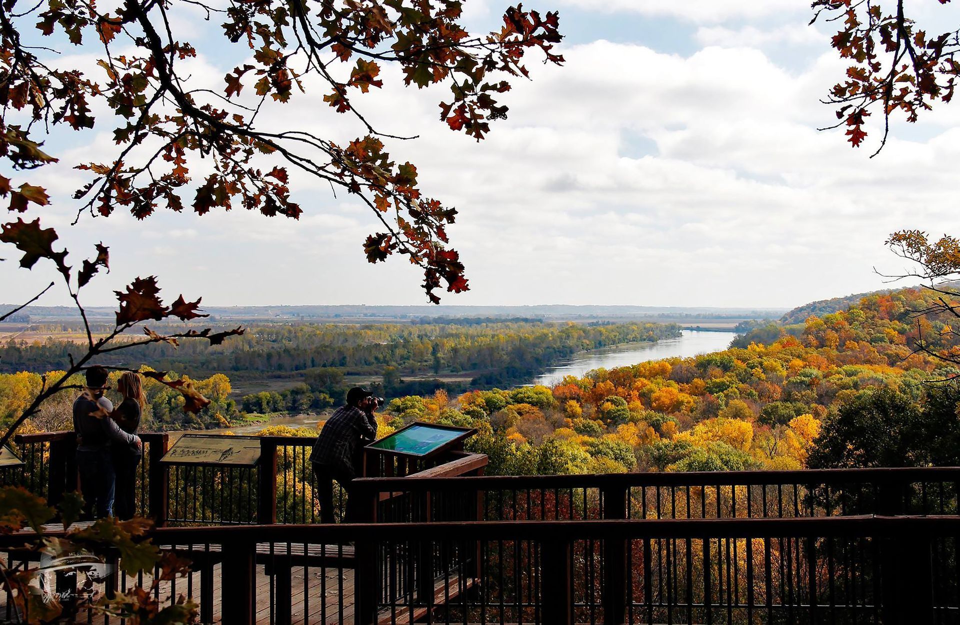 A couple sitting on a balcony overlooking a river