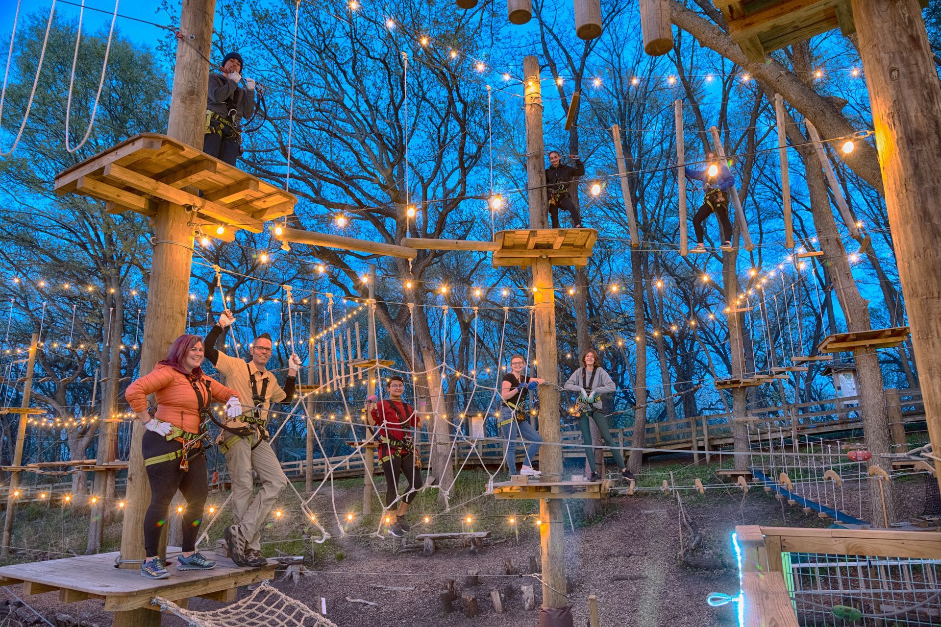 A group of people are standing on top of a ropes course.