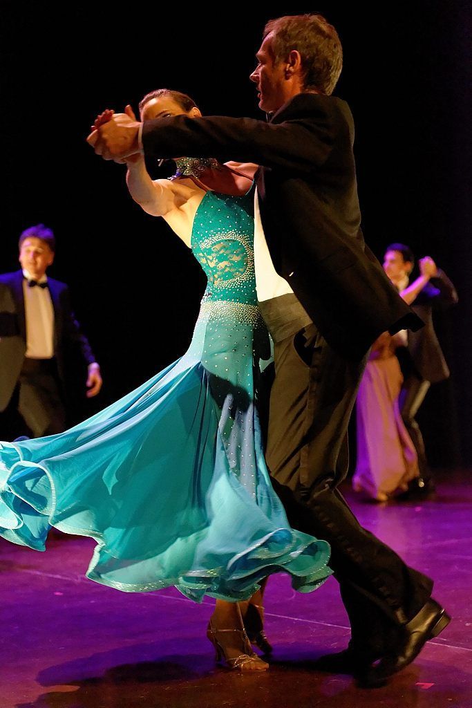 Un homme en smoking danse avec une femme en robe bleue