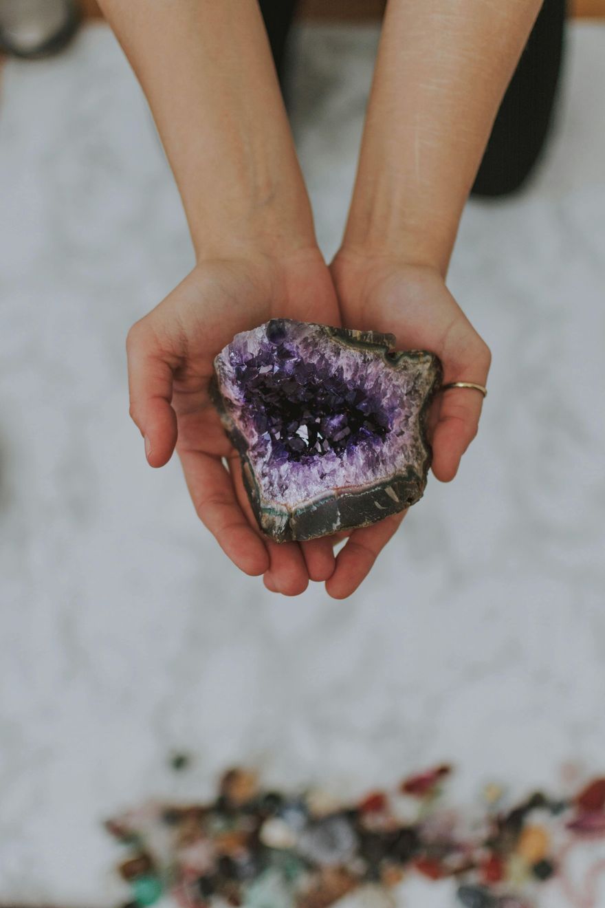 Eine Person hält ein Stück violetten Amethyst in den Händen.
