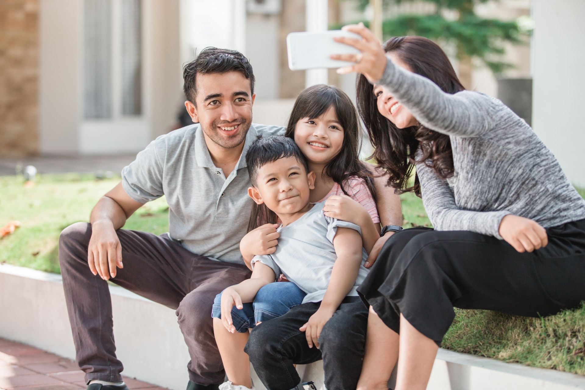 Group of people in a bright office, discussing papers. A woman holds documents, others listen.