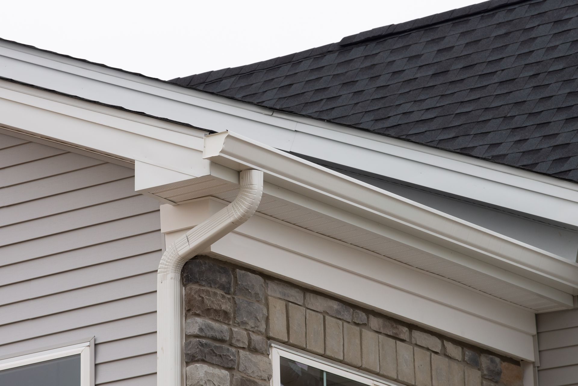 A house with a white gutter and a black roof
