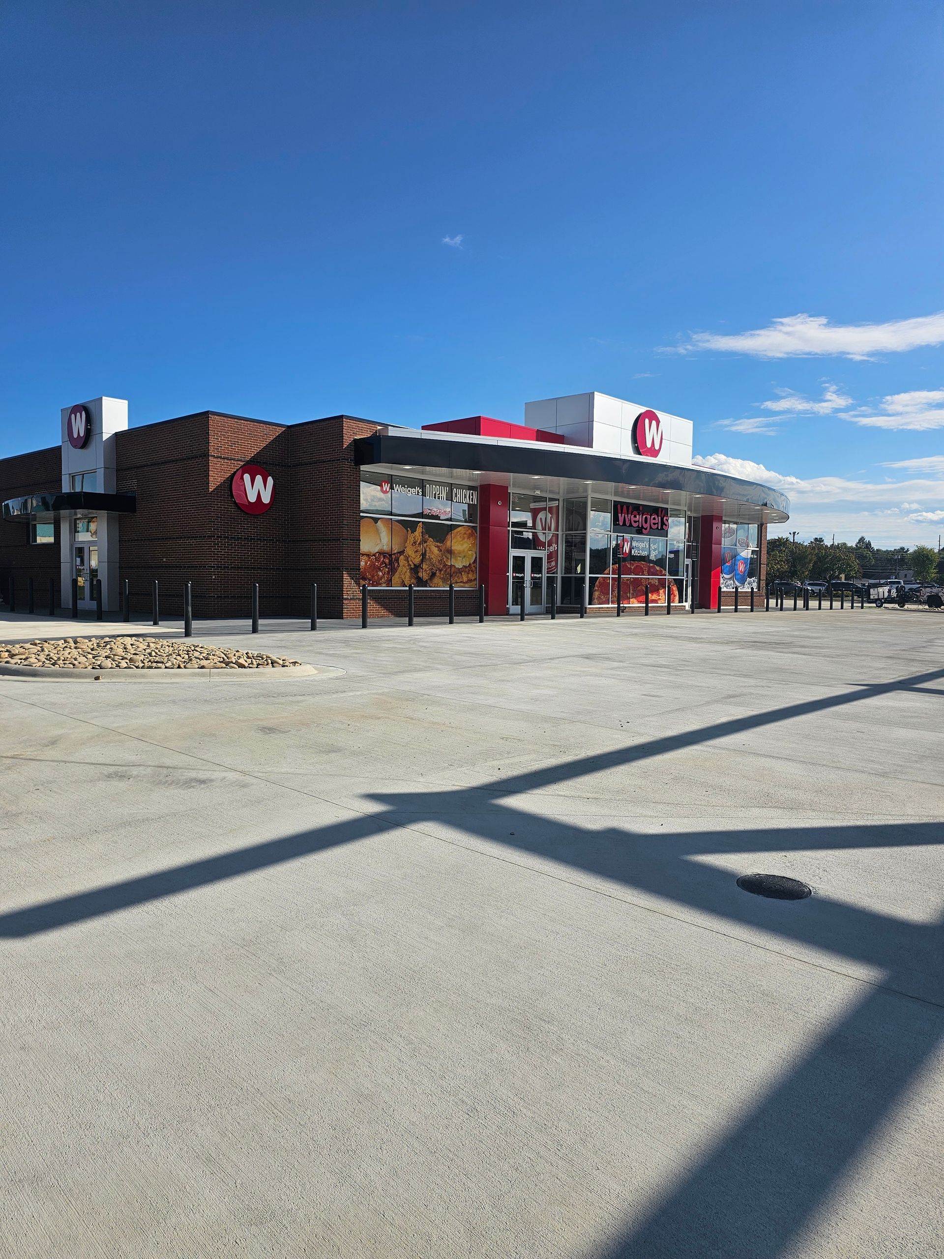 Drive-thru coffee shop with red-and-white signage and large windows on a sunny day
