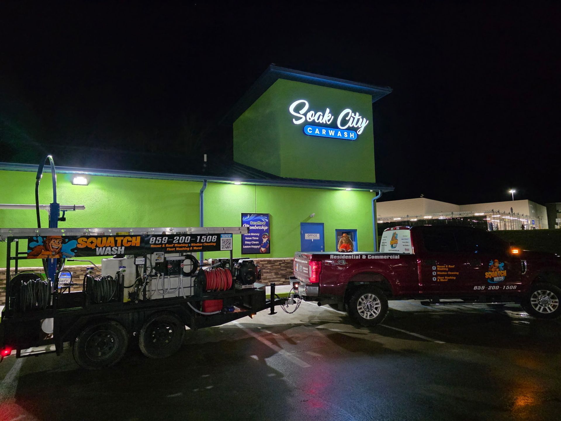 Nighttime exterior of a green-and-blue restaurant with parked trucks out front.