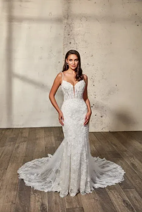 Woman in white lace wedding dress with a long train.