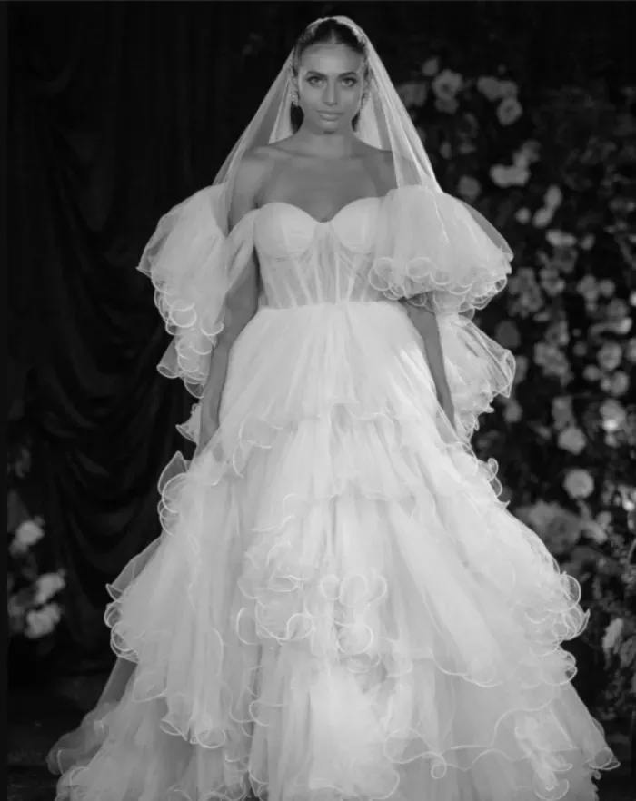 Bride in off-the-shoulder layered tulle gown and veil, in black and white.